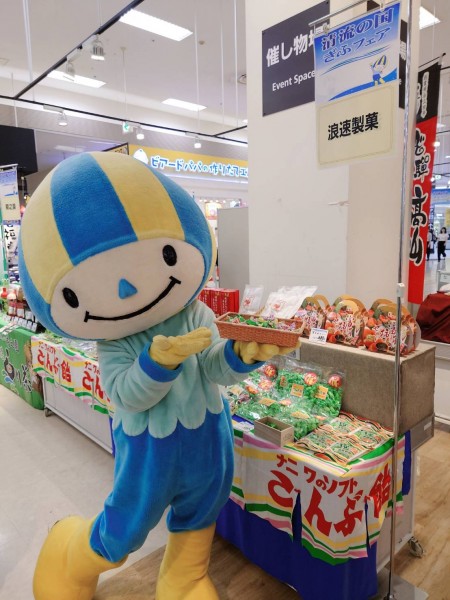 イオン熱田店にて　清流の国ぎふフェア会場でゆるキャラミナモと浪速製菓のブースで撮影した写真　ミナモがこんぶ飴の試食を持って案内してくれています